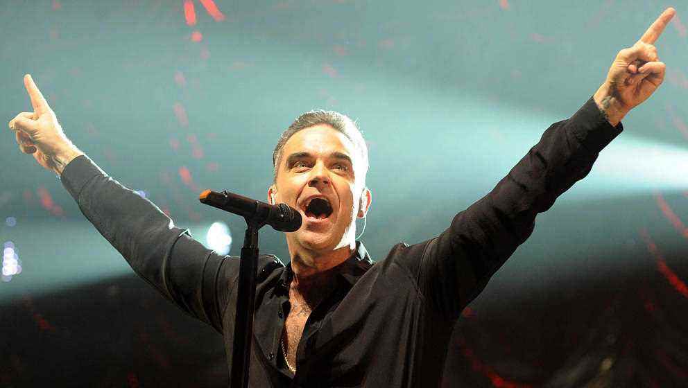 MANCHESTER, INGLATERRA - 09 DE DICIEMBRE: Robbie Williams se presenta en el escenario en Key 103 Christmas Live en Manchester Arena en diciembre