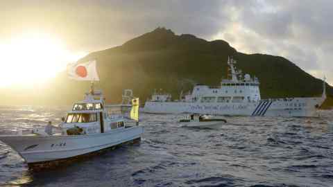 Un buque de vigilancia marítima chino, a la derecha, pasa cerca de las Islas Senkaku de Japón en el Mar de China Oriental.