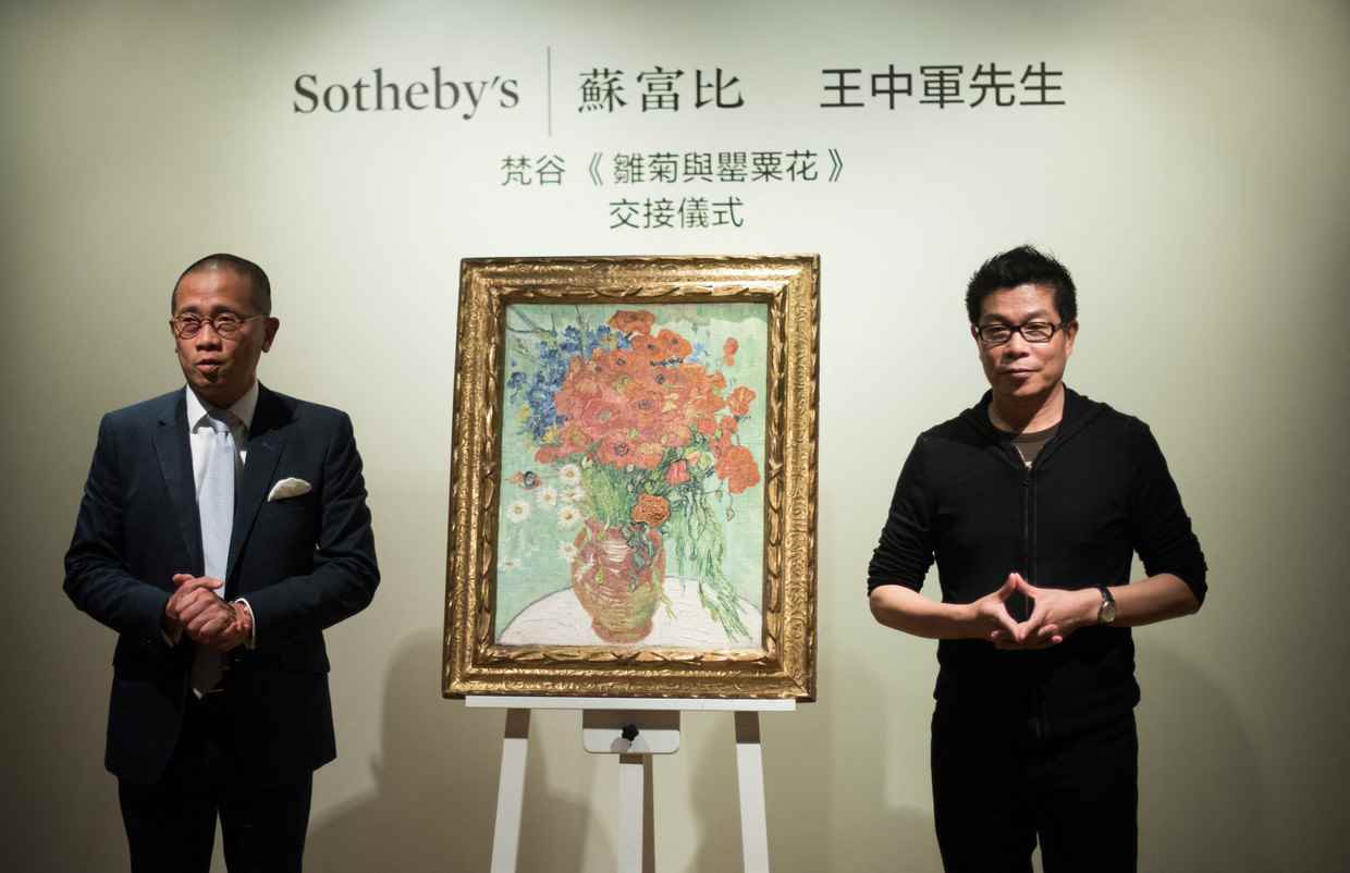 Kevin Ching (izq.), director general de Sotheby's Asia, en la entrega en 2014 del cuadro 'Jarrón de amapolas rojas y margaritas' a su nuevo 'propietario', el productor de cine chino Wang Zhongjun (der.).  Imagen AFP