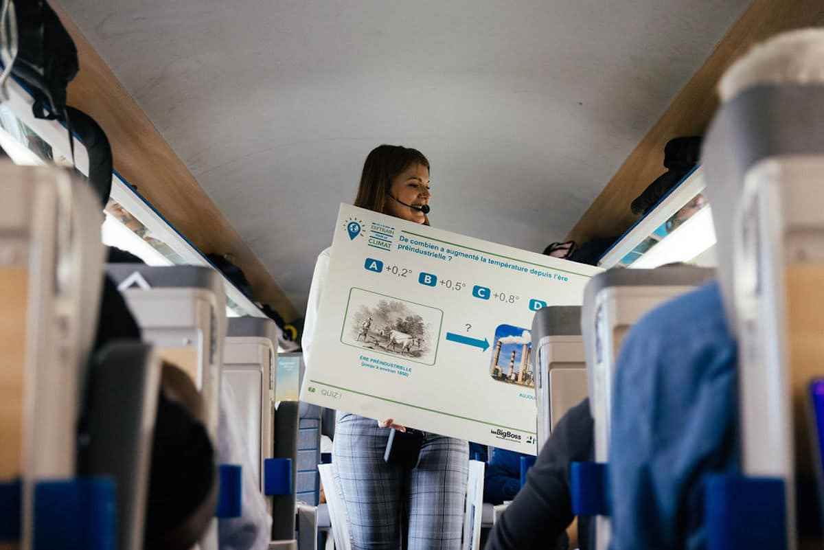 una mujer con un cartel para crear conciencia sobre las causas ambientales en un tren