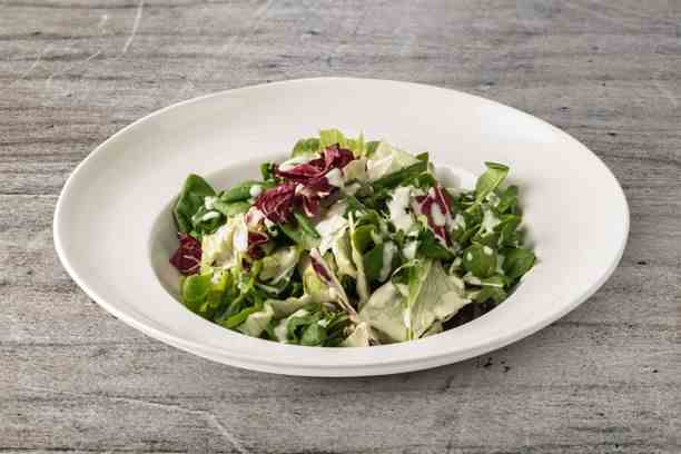 Vous obtenez une salade rapide et savoureuse lorsque vous versez le mélange de salade préparé dans une assiette et que vous y ajoutez la vinaigrette.