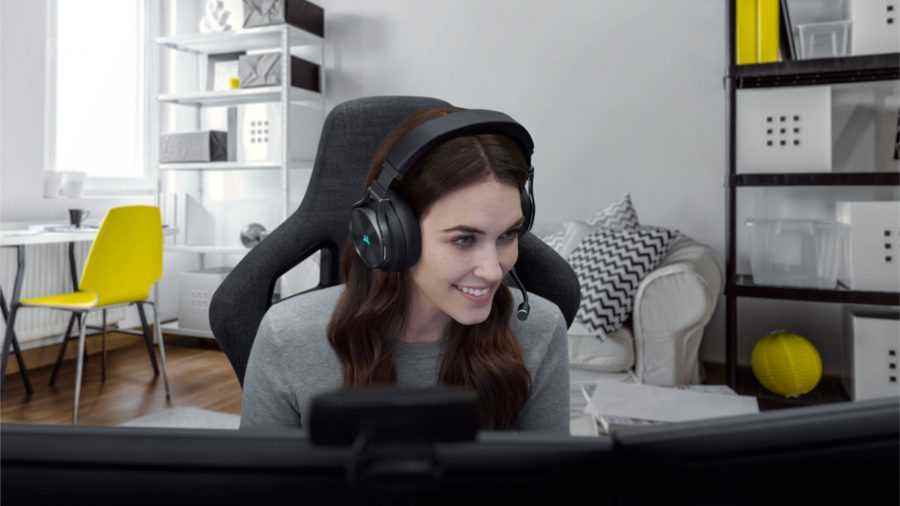 Bir kadın, Corsair Virtuoso RGB Wireless XT oyun kulaklığını kullanarak oyun bilgisayarında oynuyor