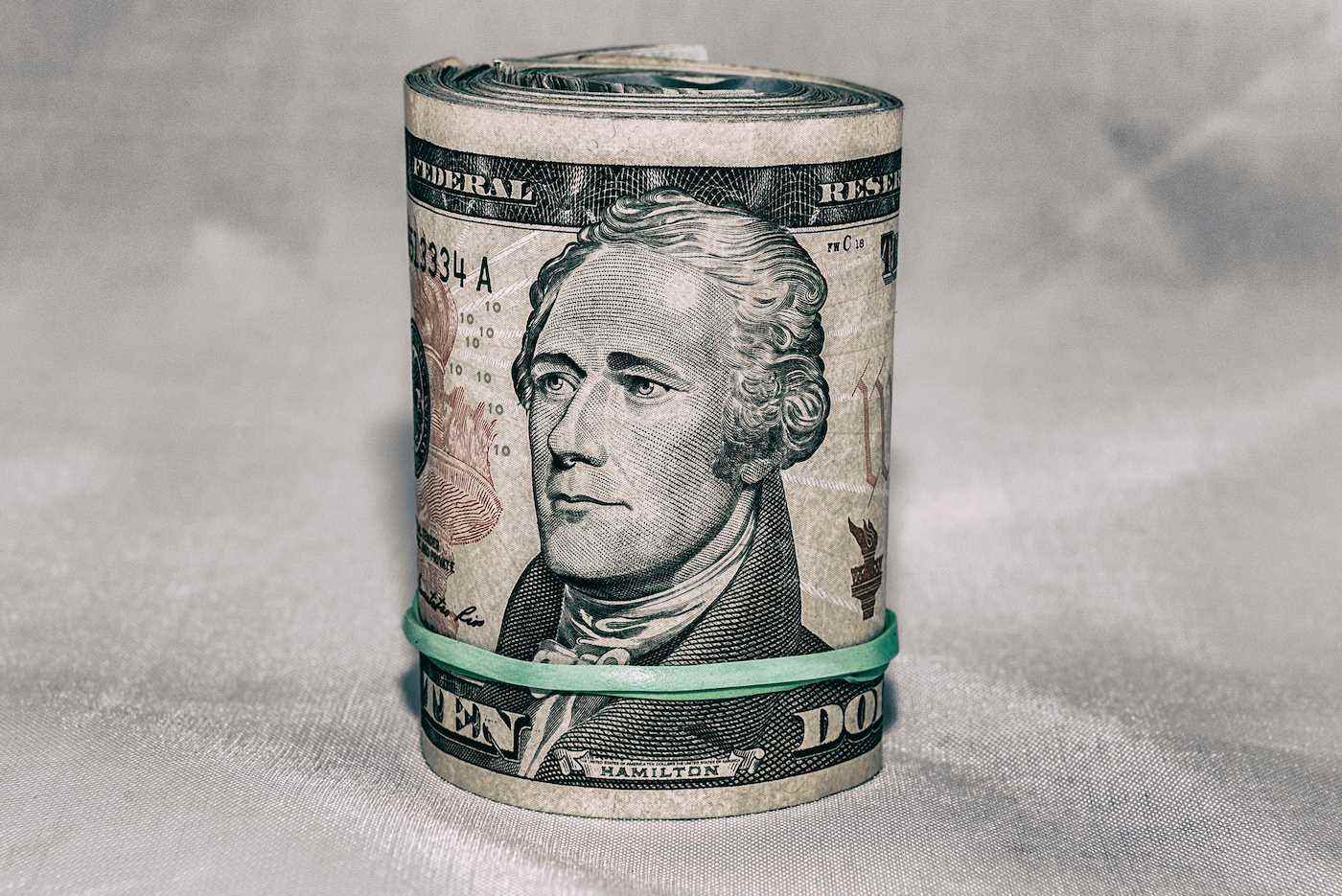 Dışında 10 dolarlık banknot, ortada Alexander Hamilton'ın portresi olan bir ABD parası rulosu.