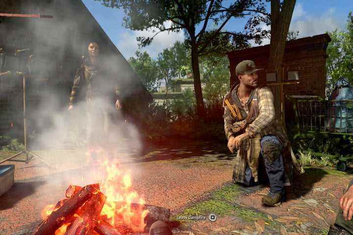 Dying Light 2'de hayatta kalanlar bir kamp ateşi etrafında oturuyorlar.