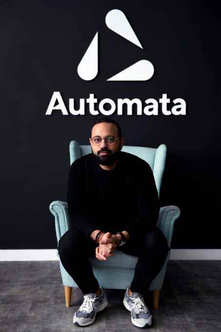 CEO Mustafa ElSayed, Automata logosunun altındaki bir sandalyede oturuyor.