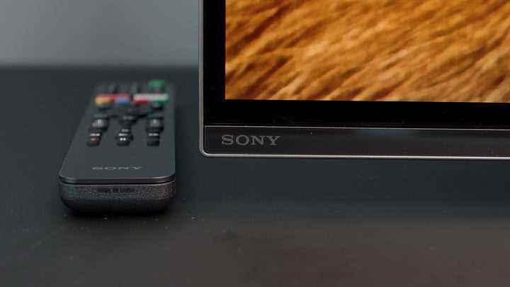 Yanındaki masanın üzerinde uzaktan kumandası bulunan bir Sony A8H OLED'in alt köşesi. 