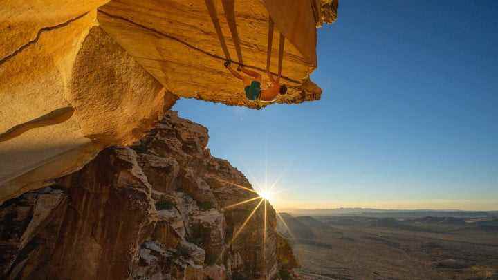 Alex Honnold, The Soloist VR'da güneş batarken bir dağın kenarına tırmanıyor.