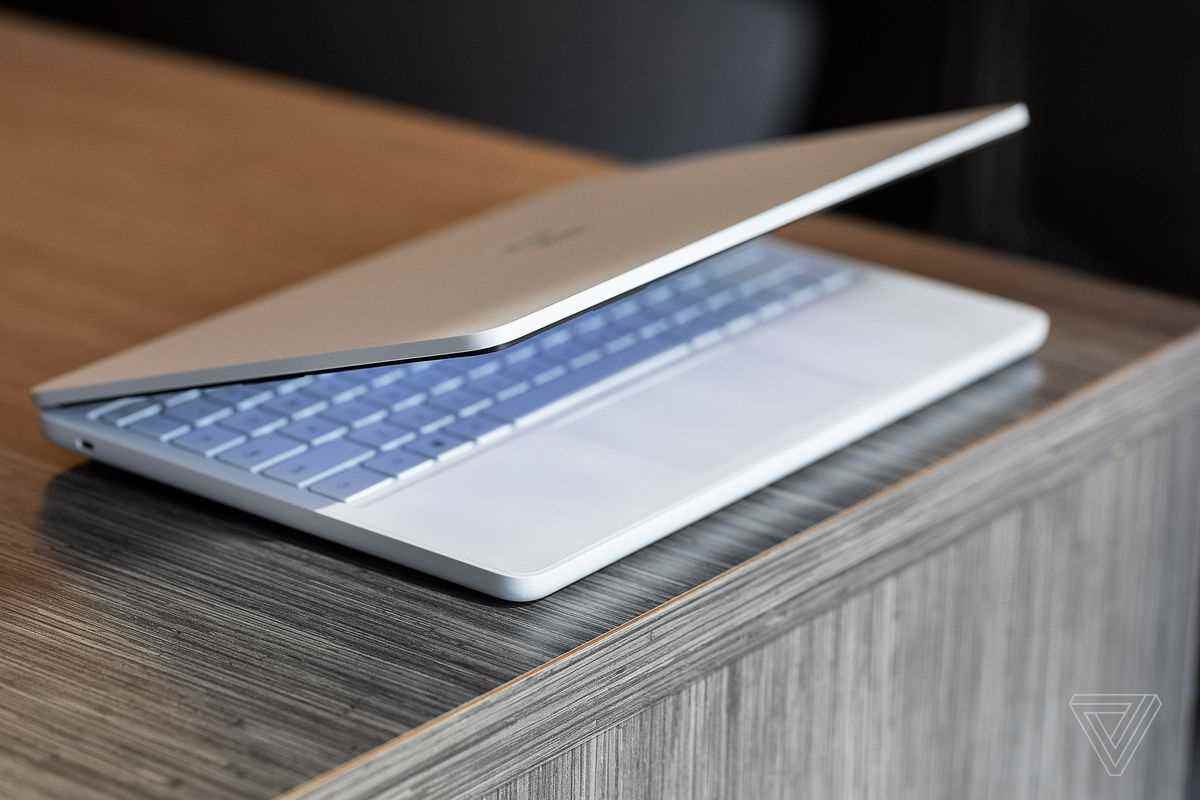 Surface Laptop SE, ahşap bir masanın kenarında yarı açık.
