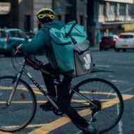 Sokakta bisikletiyle bir Deliveroo teslimatçısı