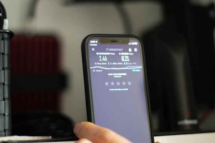 Bir RV kabininin önünde hız testi gösteren bir akıllı telefonun yakından görünümü