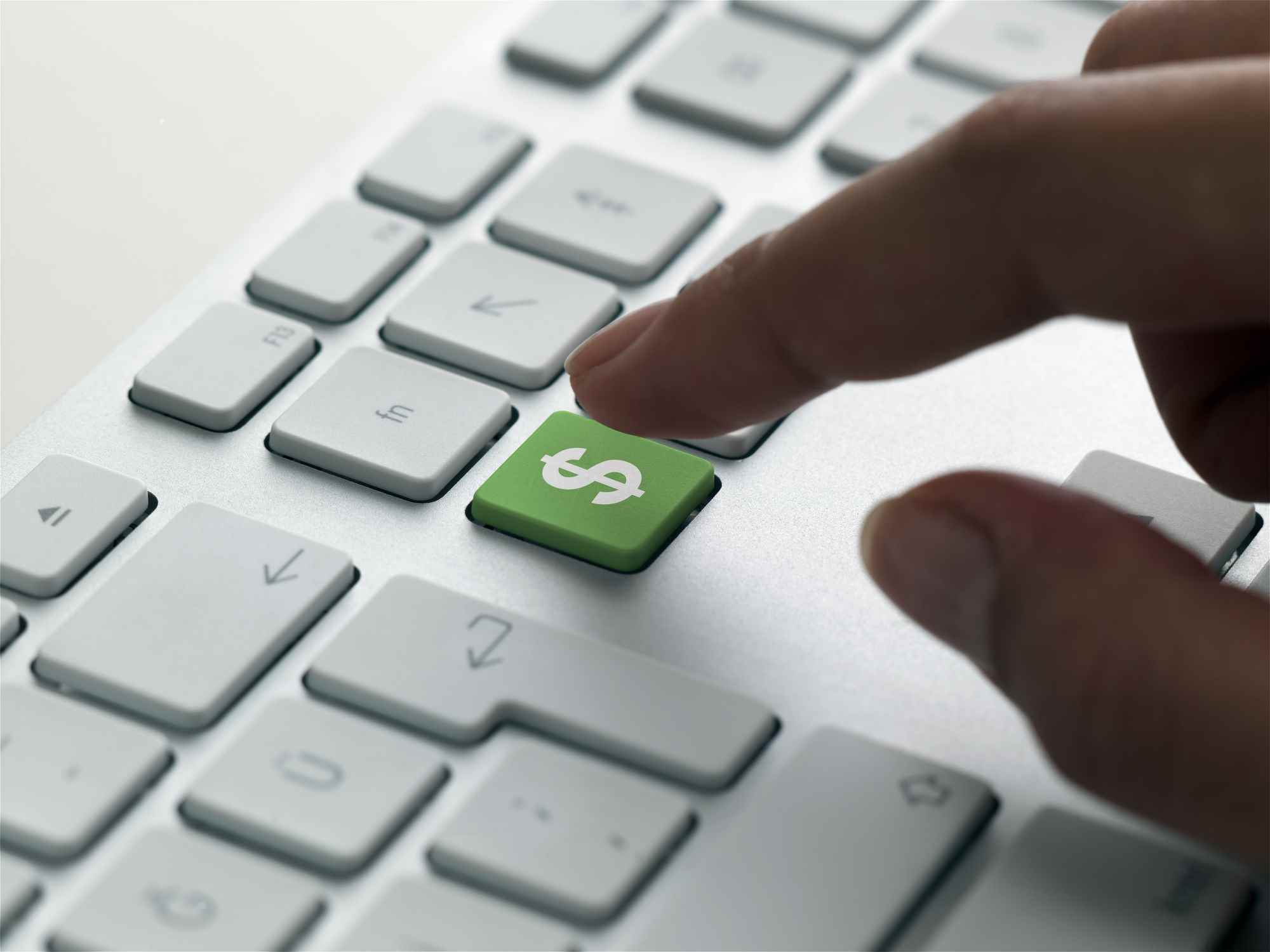 2022'de BT harcamalarını belirten bir klavyede yeşil dolar işareti tuşuna basmak üzere olan parmak