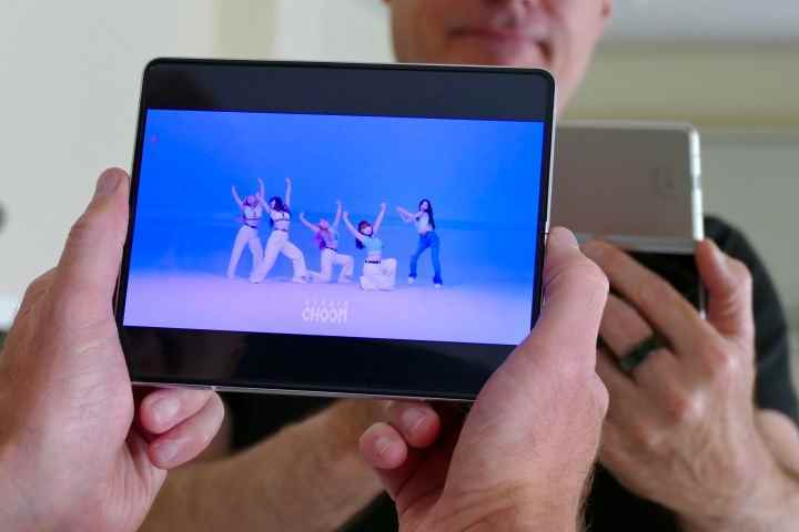 Açık ekranda video oynatırken bir adam tarafından tutulan Galaxy Z Fold 3.