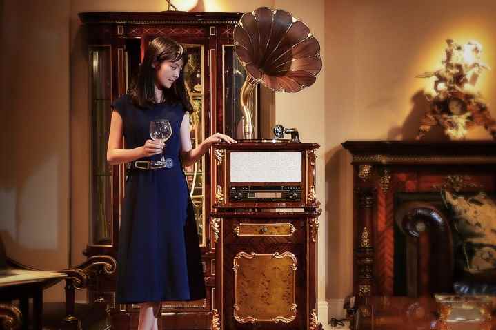 Klasik bir Fennessy gramofonunun yanında duran kadın.