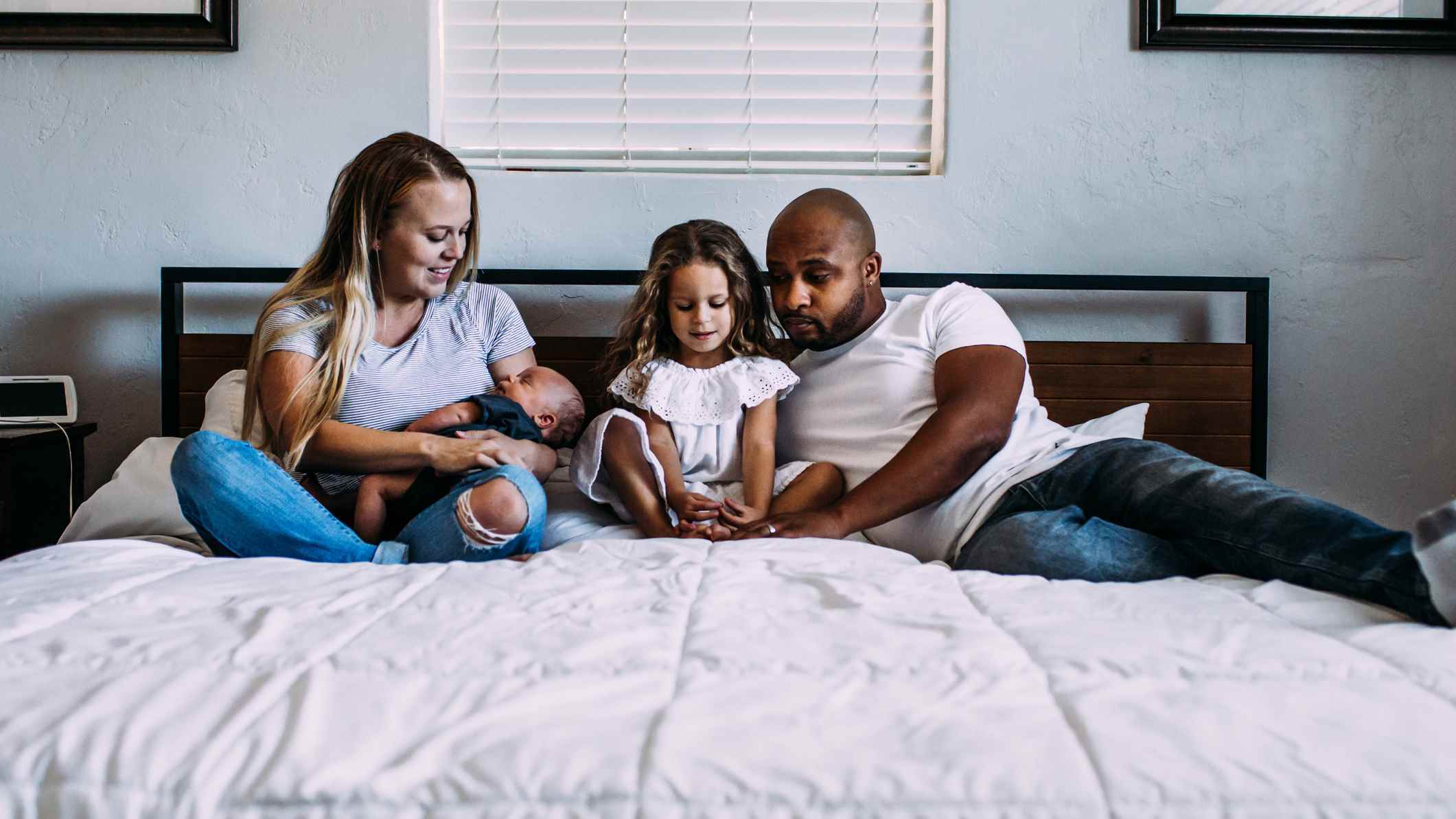Dört kişilik genç bir aile birlikte kral yatakta yatıyor.