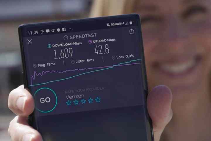 Verizon 5G Ultra Geniş Bant ağında hız testi sonuçları olan akıllı telefonu tutan kadın.