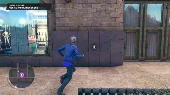 Saints Row kılavuzu: Oyuncu karakteri duvara yapıştırılmış bir telefon almak üzere.