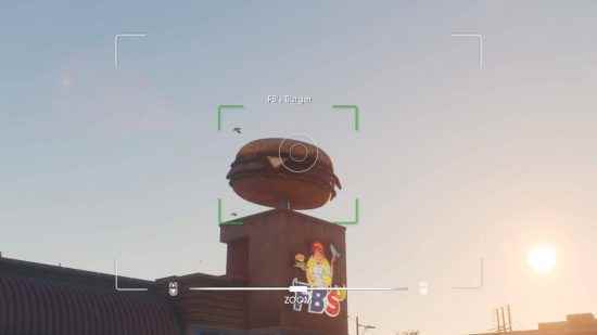 Saints Row rehberi: Bakış açısı bir kamera aracılığıyla yapılır ve odakta FB's adlı bir burger lokantasının üzerinde duran dev hamburgerin fotoğrafının çekilip çekilmediğini analiz eder.