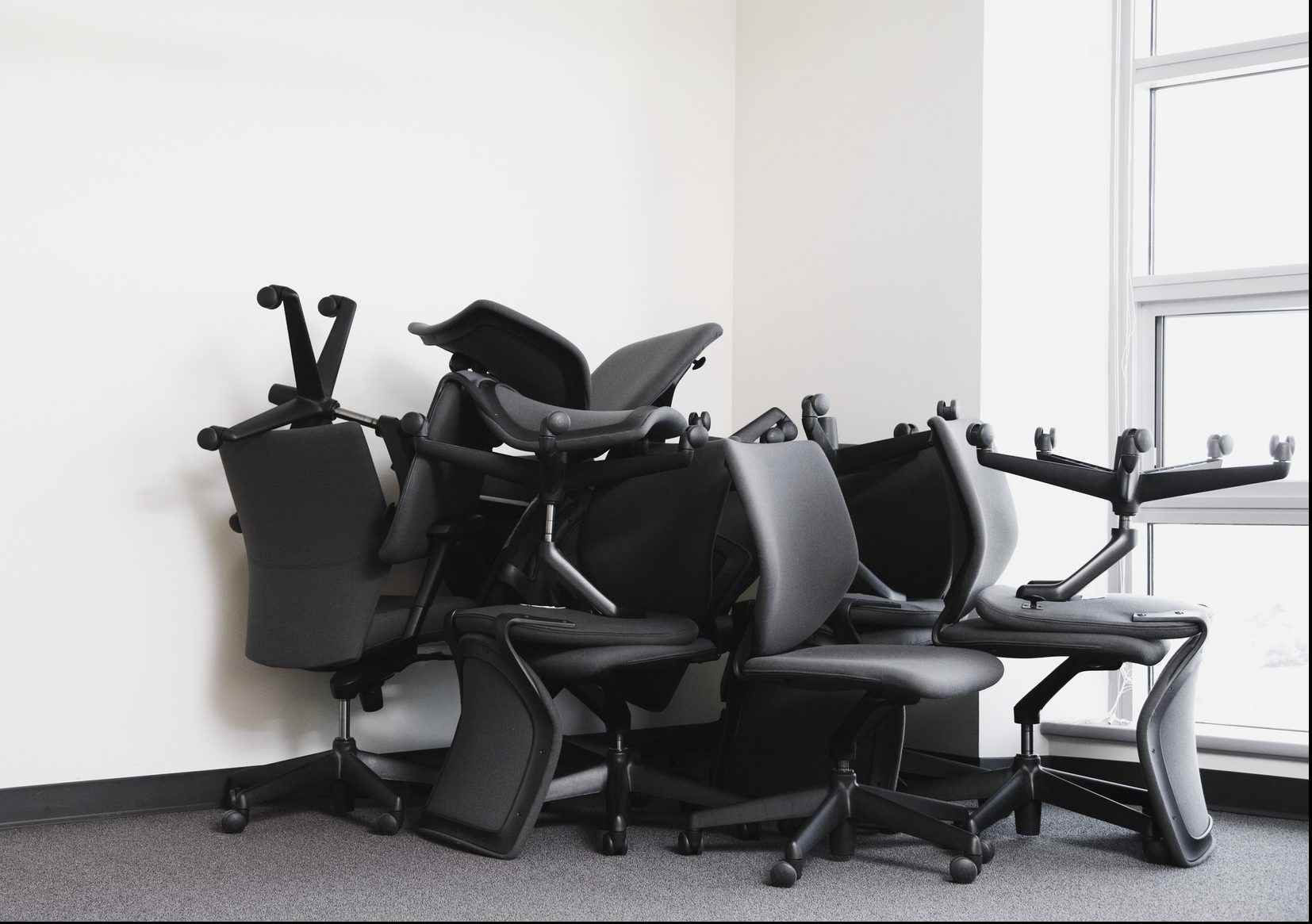 Boş ofis köşesine yığılmış ofis koltukları