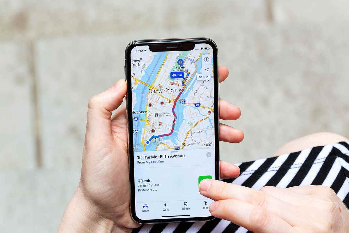 Bir kişi, Apple Haritalar'da New York'ta bir yerin yol tarifini gösteren bir iPhone'u tutar.