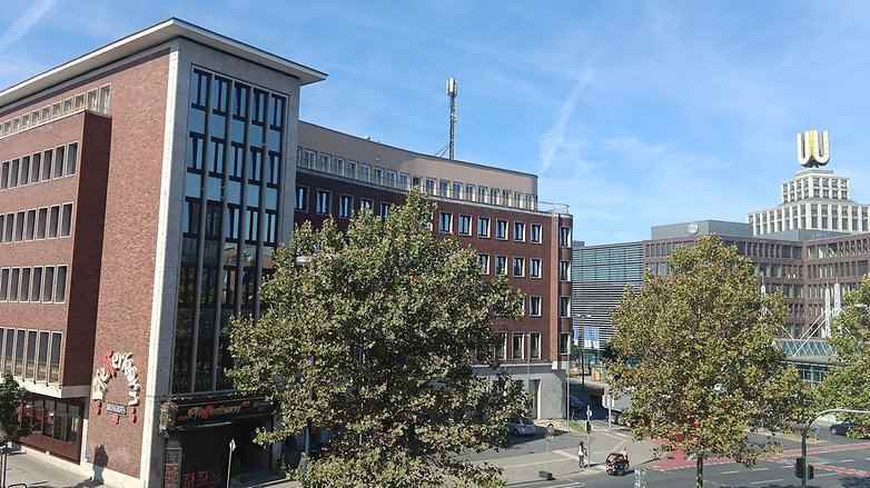 Mavi gökyüzünün altında bir otel ve U-Kulesi manzaralı Dortmund şehir merkezinin fotoğrafı