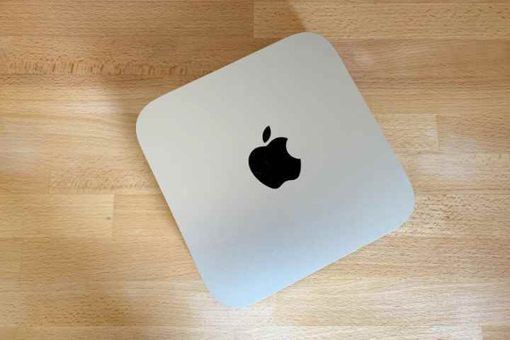 Apple'ın M1 çipiyle güçlendirilmiş 2020 Mac Mini, ahşap bir yüzey üzerinde.