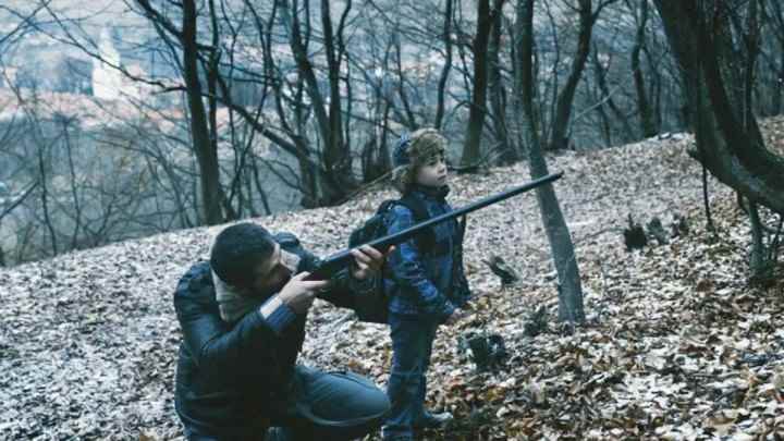 RMN'de bir adam, yanında bir çocukla silahı doğrultuyor