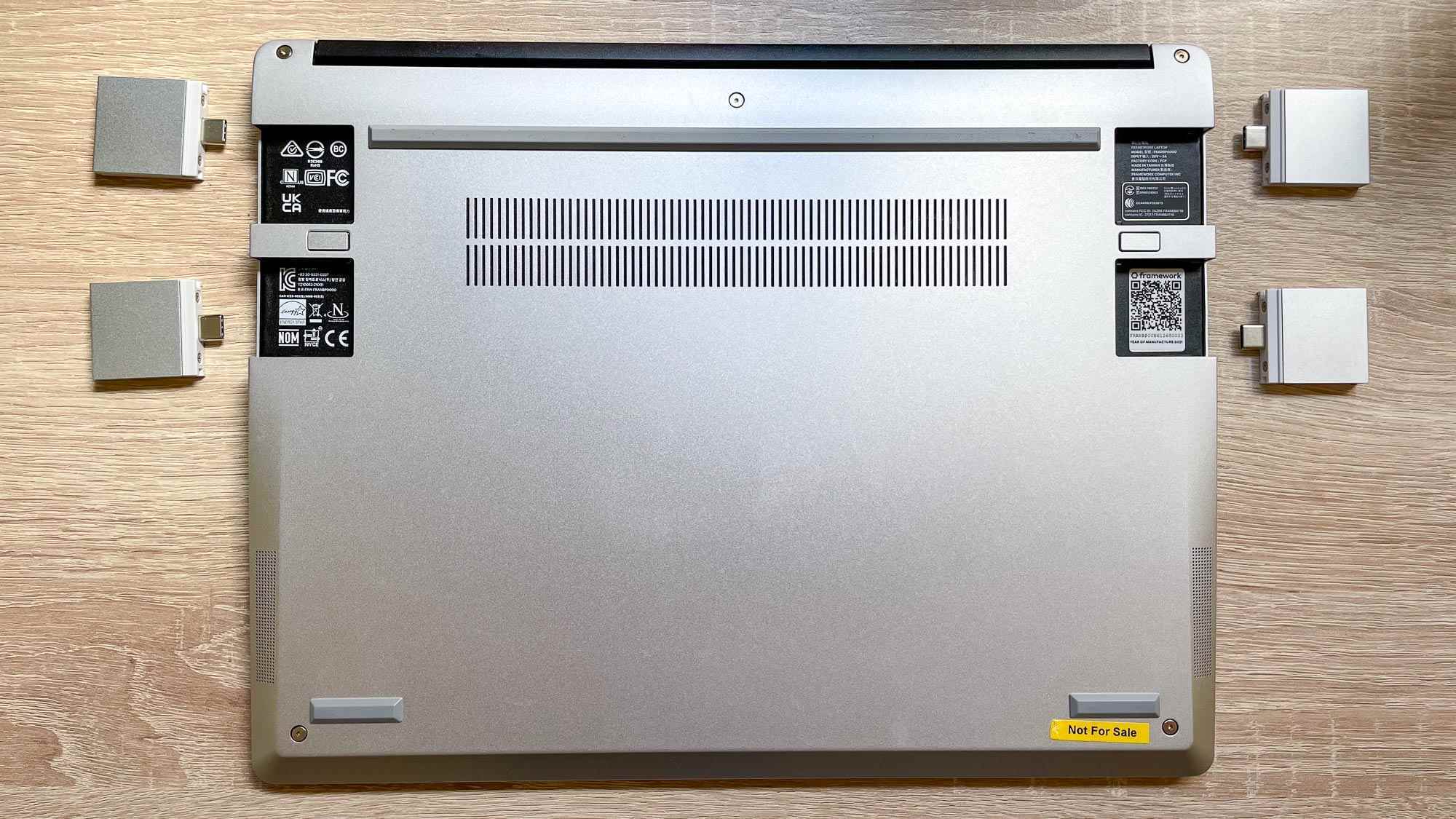 Bir masa üzerinde Çerçeve Dizüstü bilgisayar, alt kısımda genişletme kartları çıkarılmış ve yakına dizilmiş olarak gösteriliyor