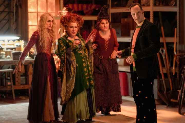 Sanderson kardeşler olarak Sarah Jessica Parker, Bette Midler ve Kathy Najimy, Hocus Pocus 2'den bir sahnede Tony Hale'in yanında duruyor.