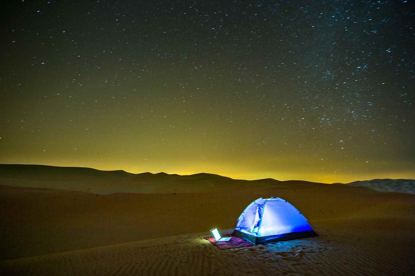 Liwa, Birleşik Arap Emirlikleri - Dizüstü bilgisayar, Boş Çeyrek çölünün kum tepelerine kurulmuş bir çadırın dışında parlıyor