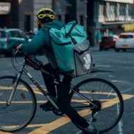 Sokakta bisikletiyle bir Deliveroo teslimatçısı.