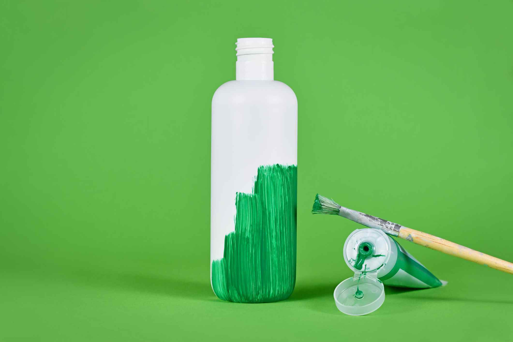 Yeşile boyanmış beyaz plastik şişe;  yeşil yıkama