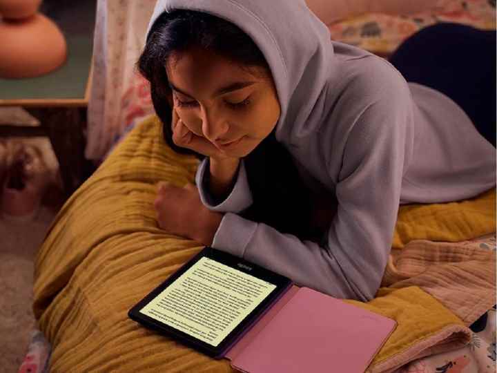 Amazon Kindle Paperwhite Kids'de e-kitap okuyan bir kız.