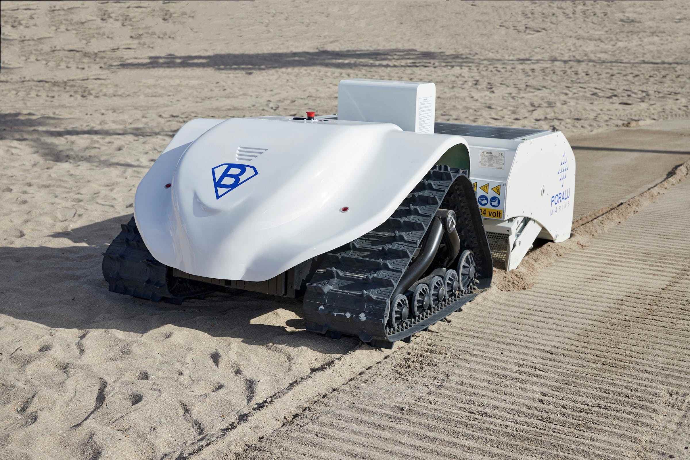 Kumlu bir plajda beyaz bir robot