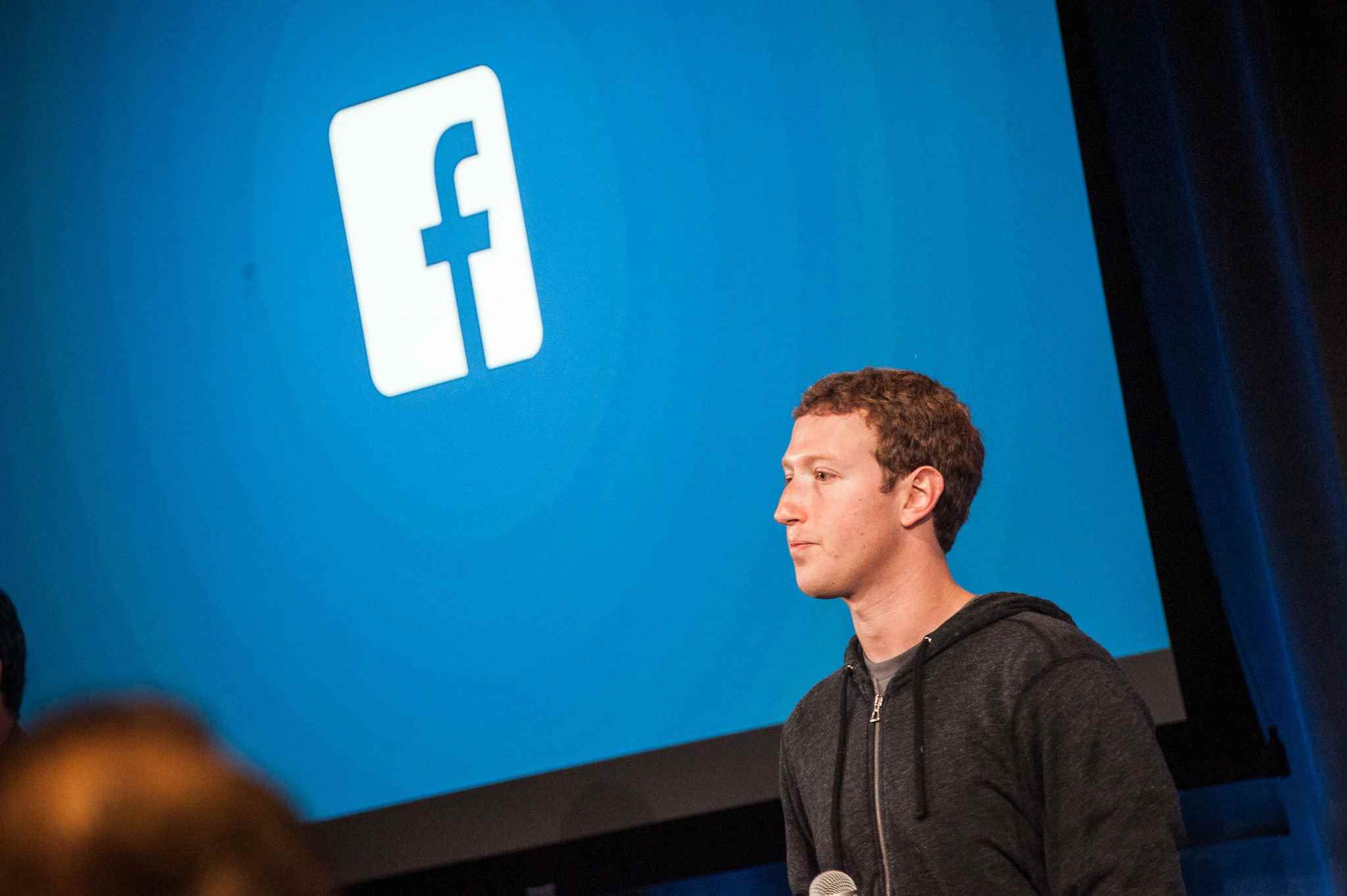 Facebook logosunun önünde Mark Zuckerberg