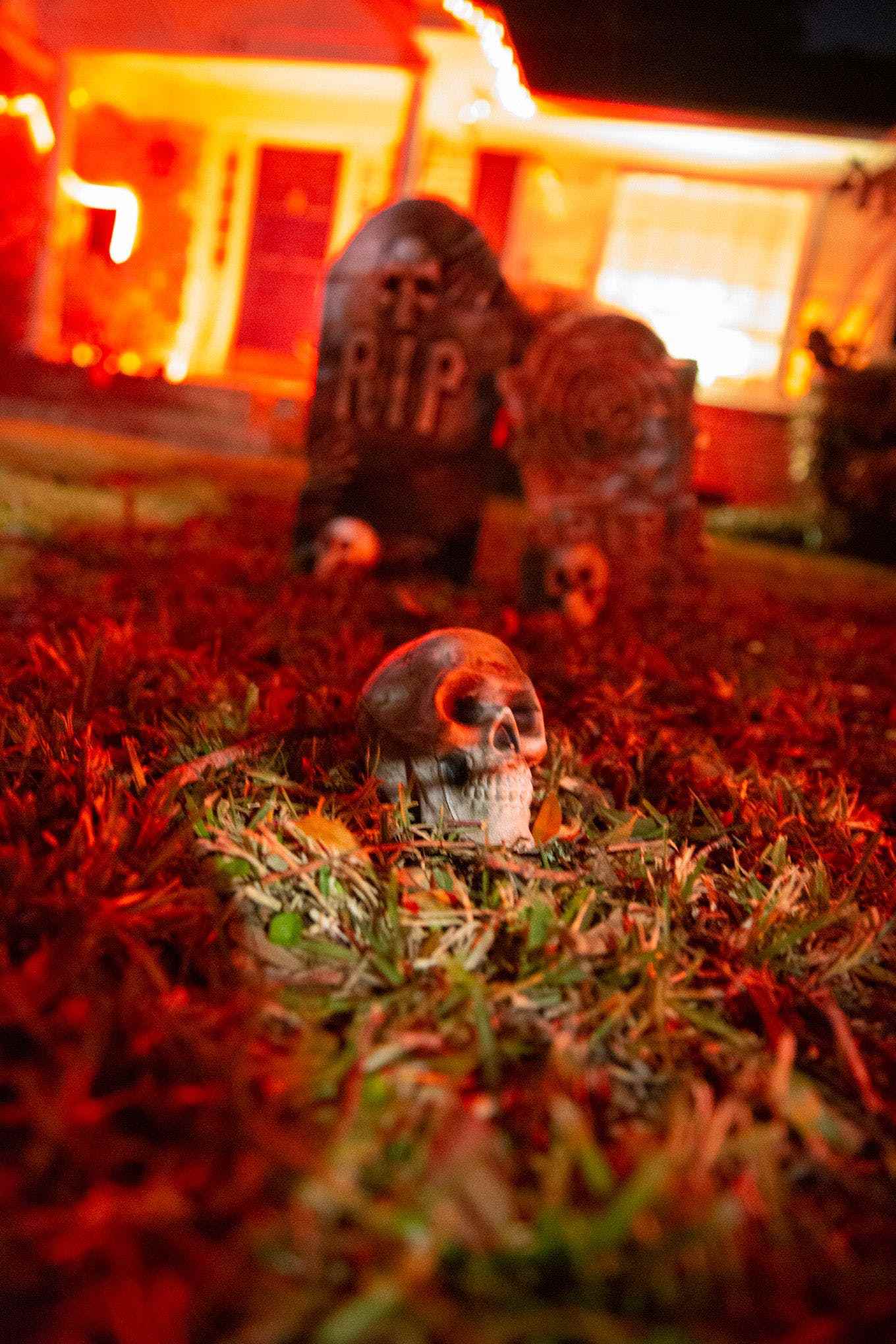 Ön bahçedeki sahte mezarların önünde plastik bir kafatası