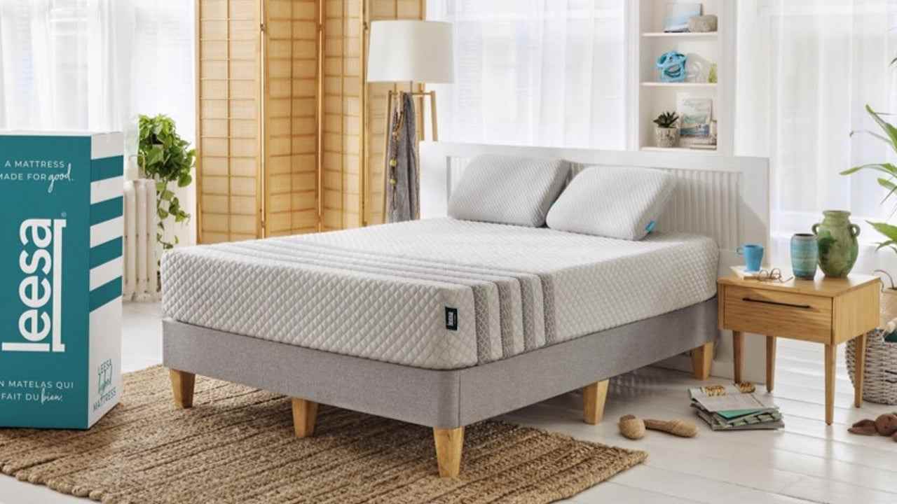 Leesa yatak satış ve indirim kodları: Açık renkli ahşap ayaklı gri bir taban üzerinde fotoğraflanan Leesa Hybrid yatak