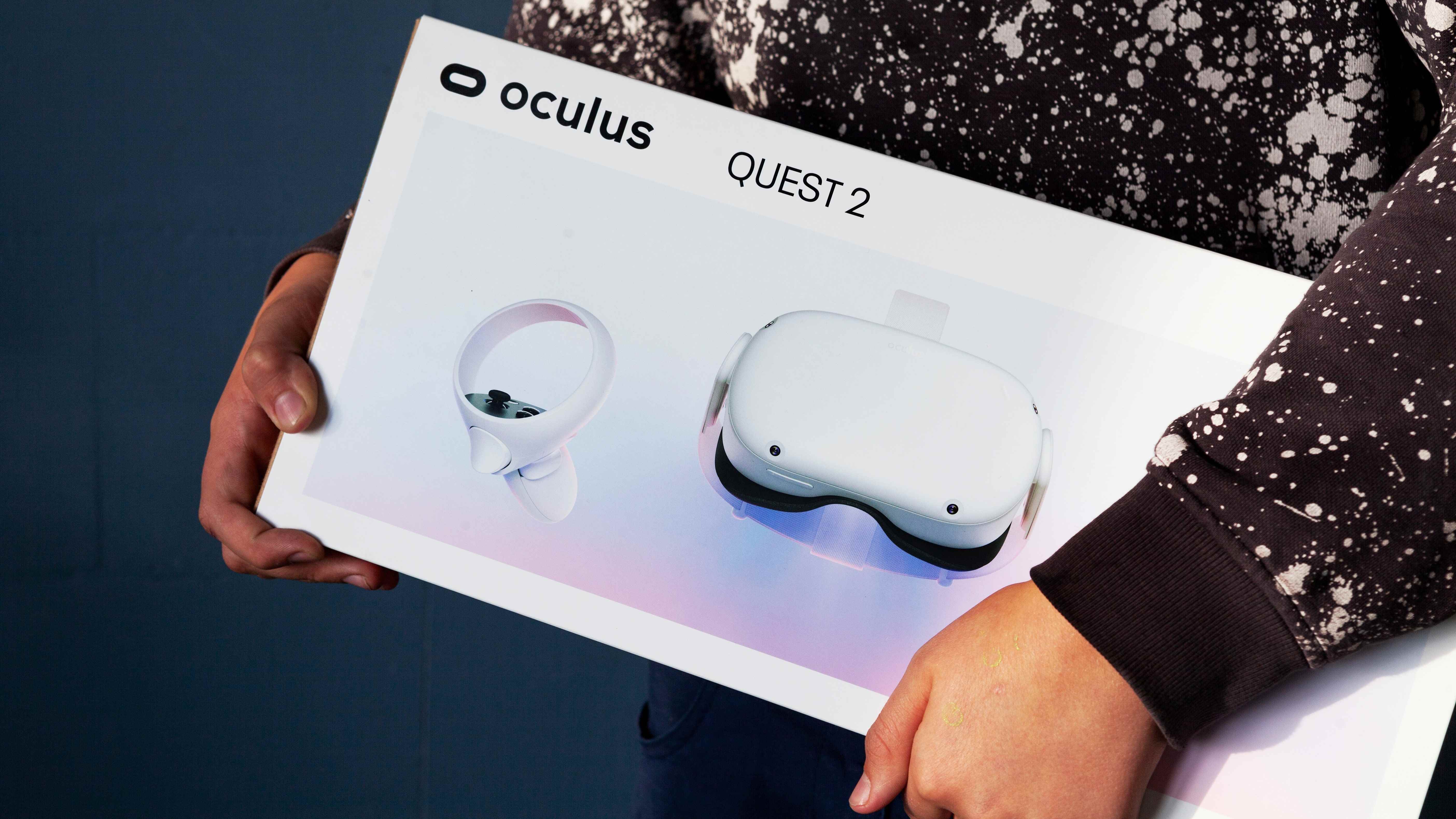 İçinde Oculus Quest 2 VR başlığı olan bir kutu taşıyan bir kişi