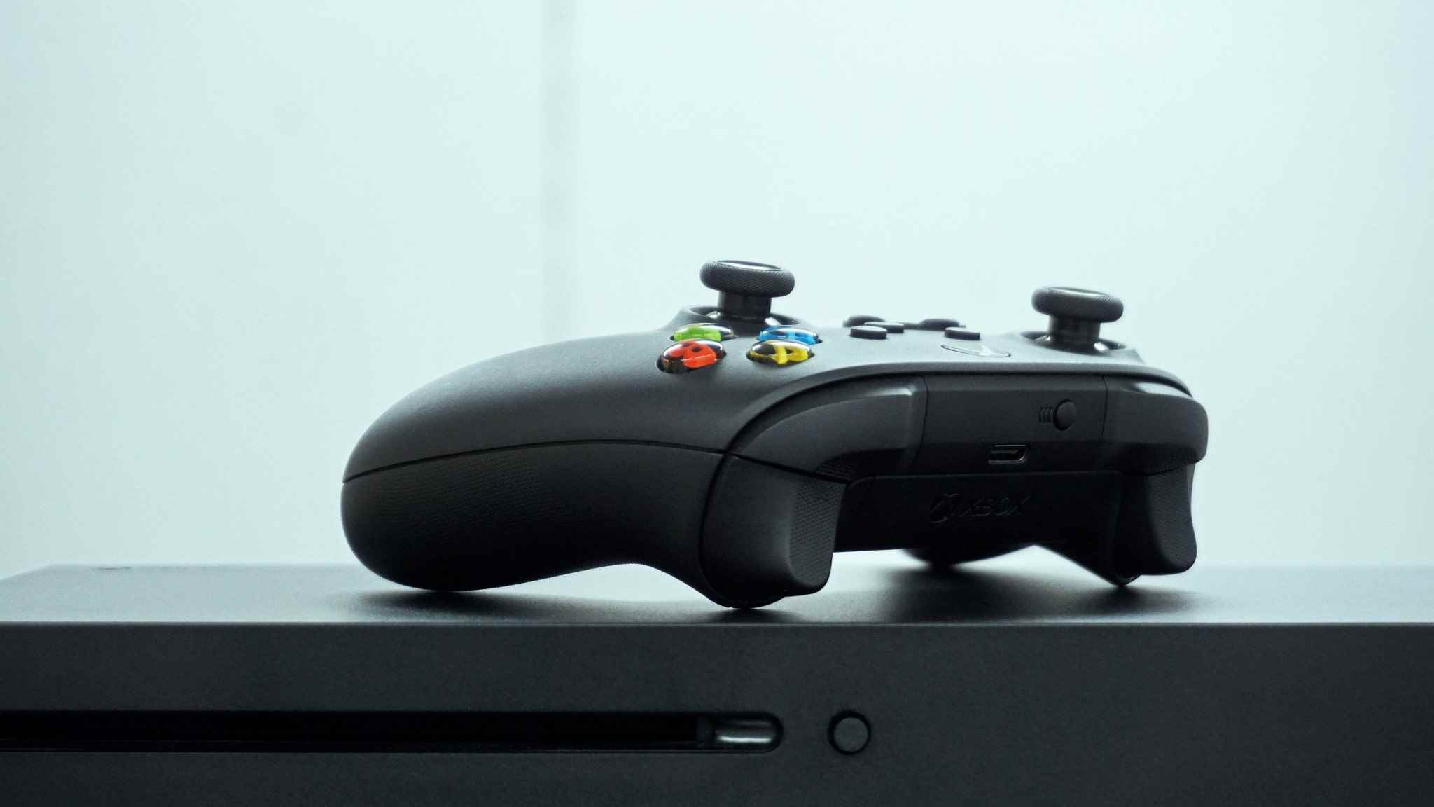 Xbox Kablosuz Oyun Kumandası ile yan yana yatan Xbox Series X'in görüntüsü.
