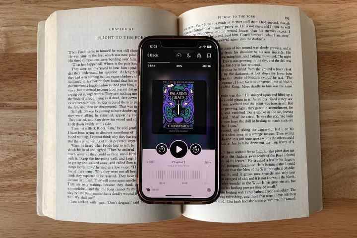 Açık bir kitap üzerinde duran bir iPhone 12'de görüntülenen Libby uygulaması.