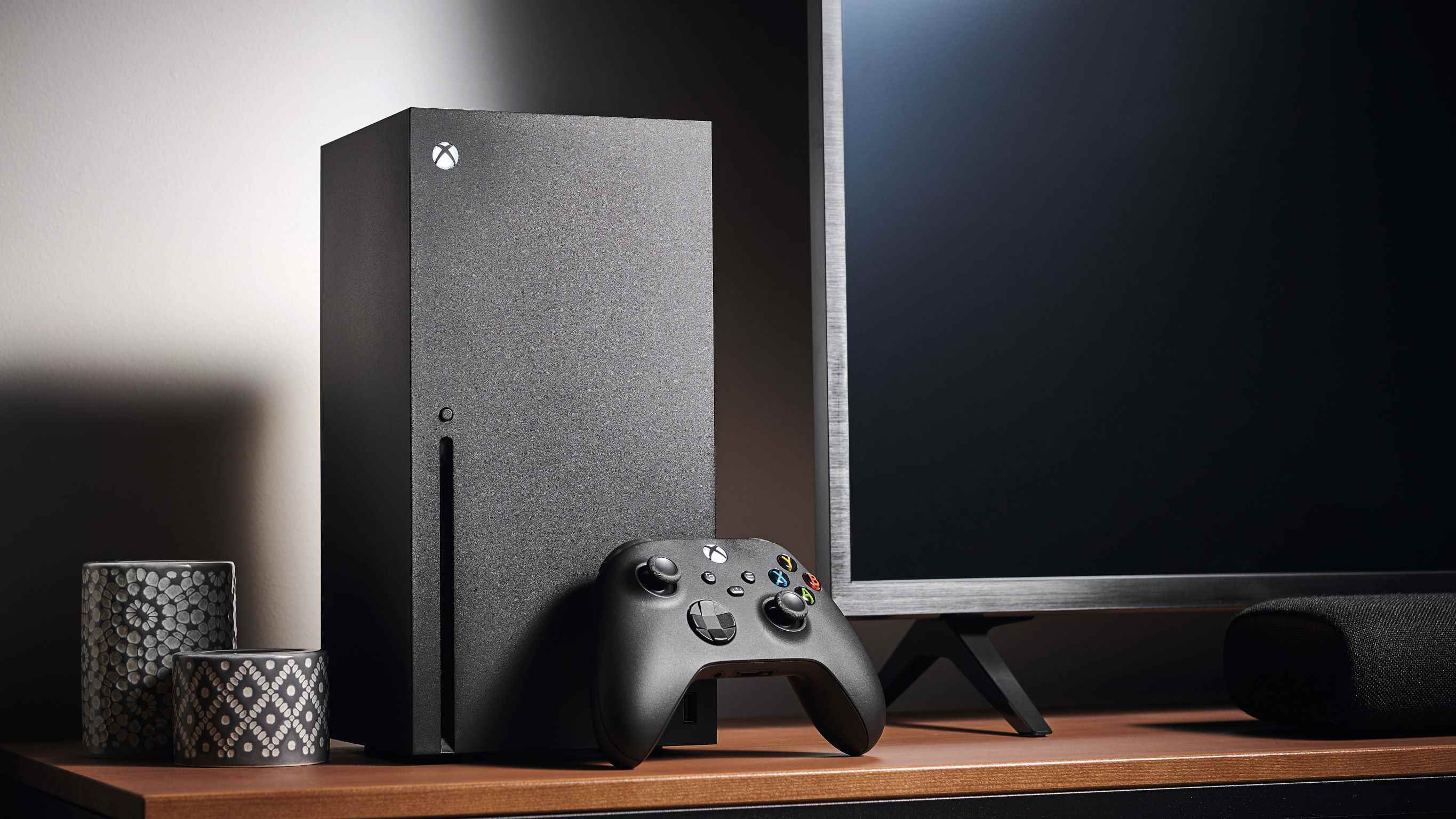 TV standında bir Xbox Series X ve bir Oyun Kumandası