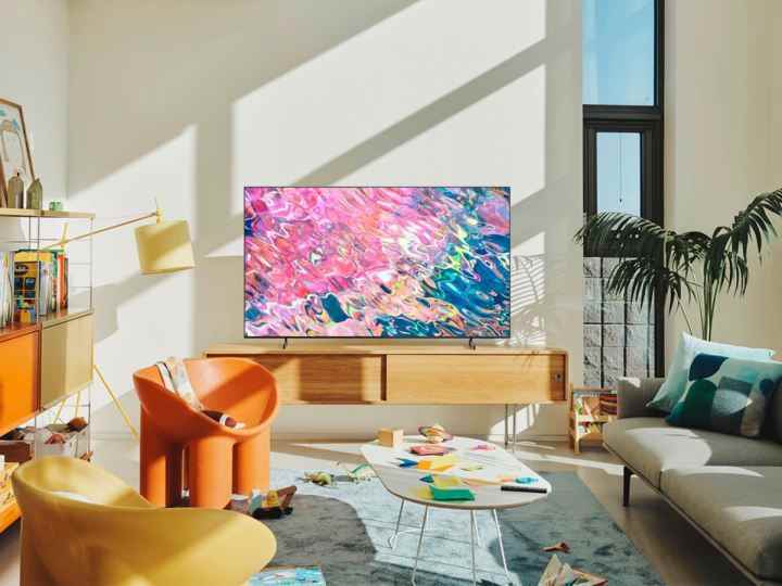 Samsung Q60B QLED Smart TV, oturma odasındaki medya dolabının üzerinde duruyor.
