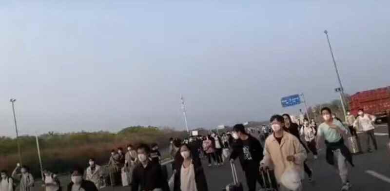 Videodan alınan ekran görüntüsü, Zhengzhou'daki Foxconn işçilerinin fabrikanın kampüsünden ayrıldığını gösteriyor - Noel için iPhone 14 Pro kıtlığı konusunda endişelenen Foxconn, bir Hail Mary oyunu hazırlıyor