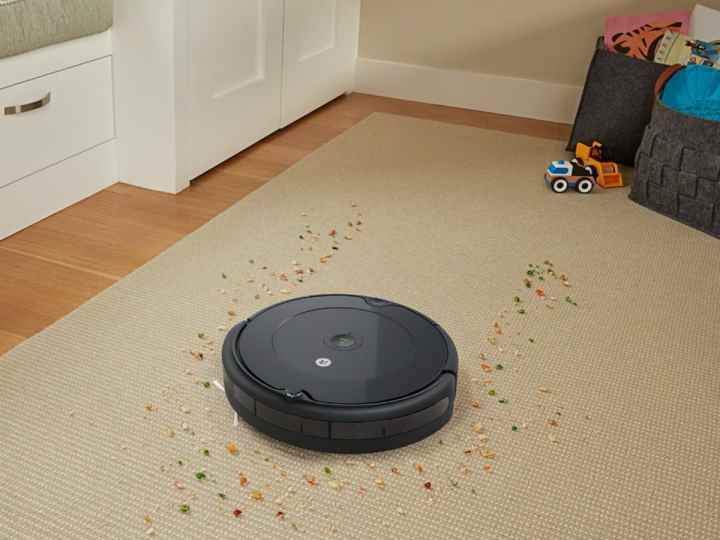 iRobot Roomba 694 Wi-Fi Bağlantılı Robot Dökülen mısır gevreğini elektrikli süpürgeyle temizler.