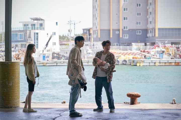 Song Kang-ho, Gang Dong-won ve Lee Ji-eun, Broker'da deniz kenarında duruyor.