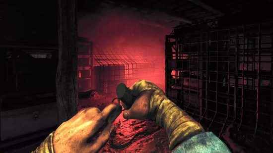 Amnesia The Bunker çıkış tarihi: Oyuncunun bir el bombasını çözüp ürkütücü bir kırmızı parıltıyla aydınlatılan kasvetli bir depo odasına atmak üzere olduğu ekran görüntüsü