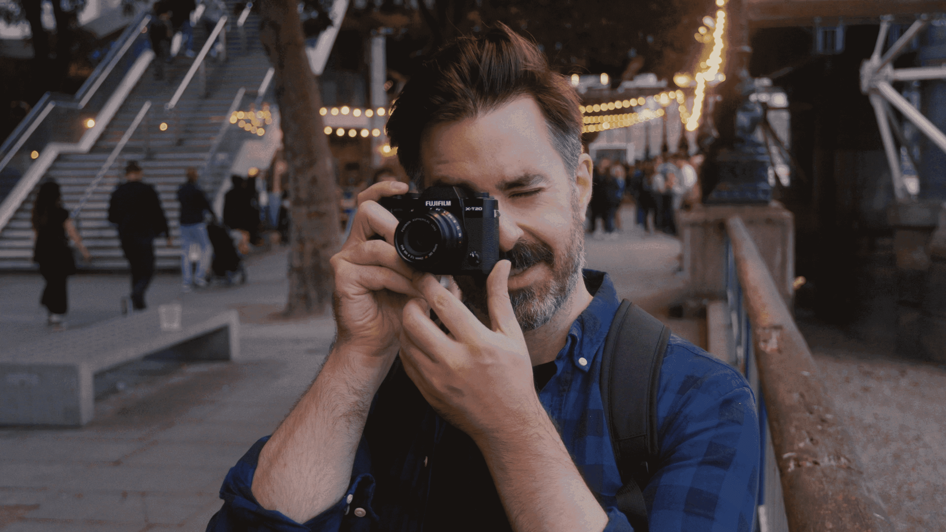 Fujifilm kamerasının lens bulucusundan bakan adam