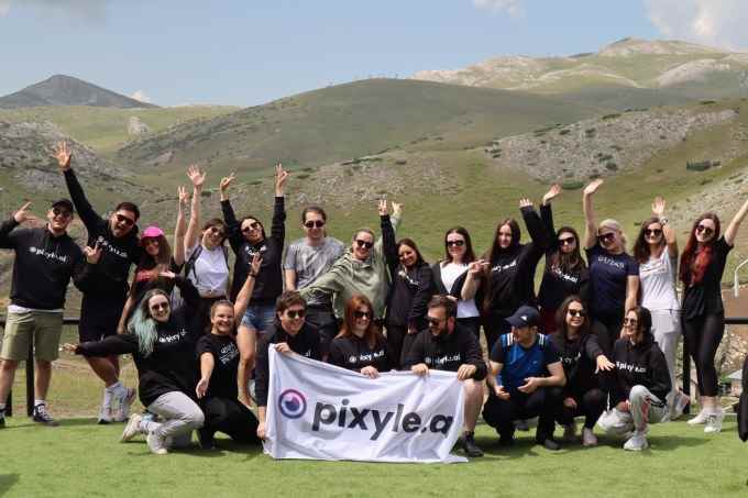 Pixyle AI ekibi yeşil bir dağın zirvesinde