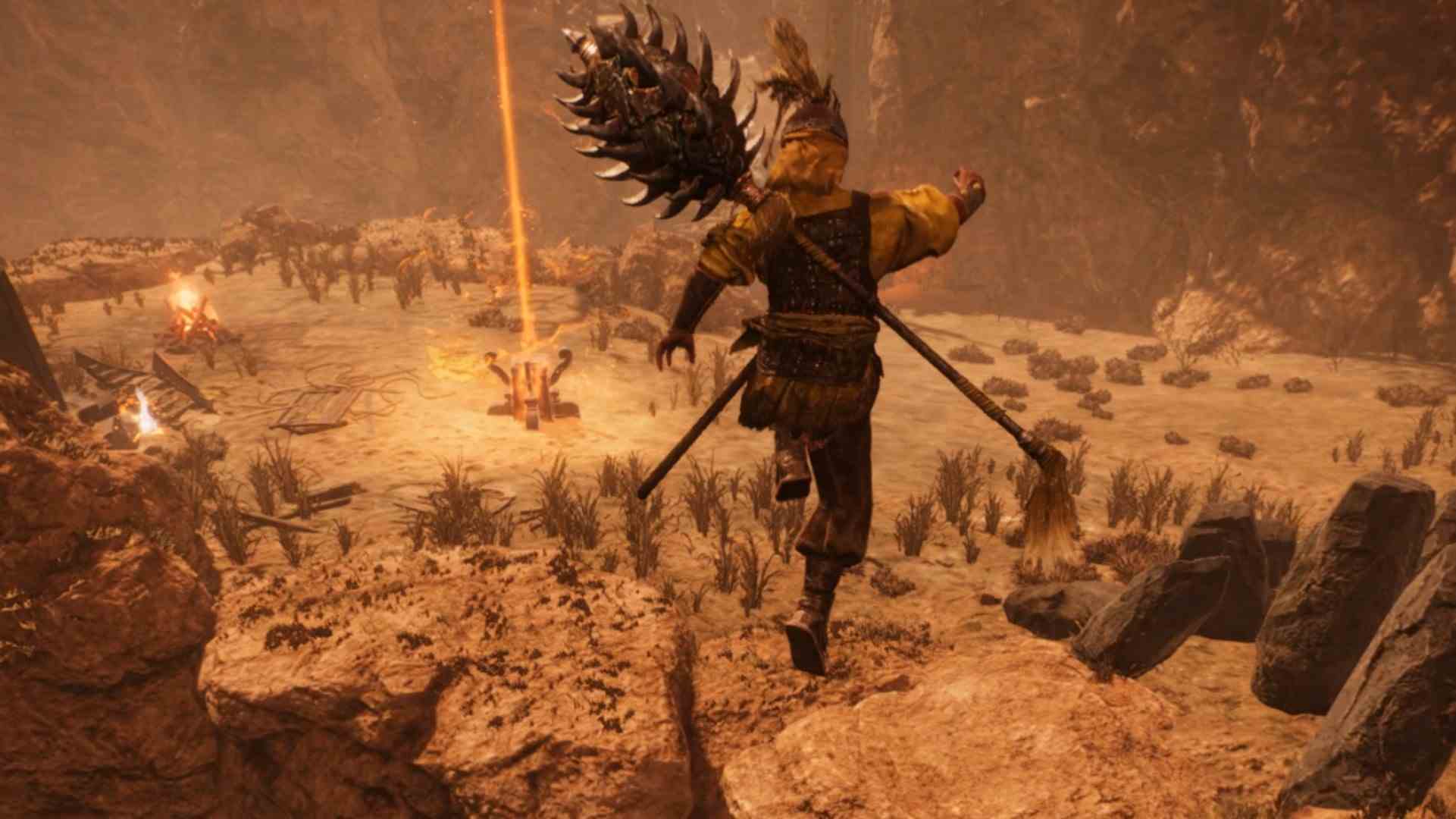 Wo Long Fallen Dynasty uygulamalı: Bir savaşçı, engebeli bir çöl kanyonu kompleksindeki bir dağ geçidinden atlar, bir sunağın yakınında, yukarı doğru altın bir ışık huzmesi yayar
