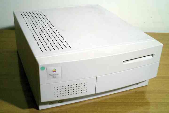 Ahşap bir masa üzerinde bir Apple Macintosh IIvx bilgisayar.