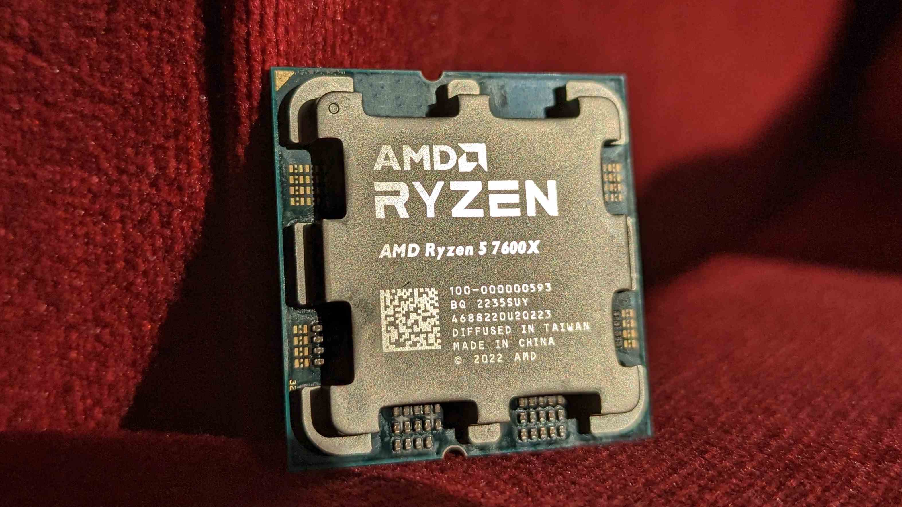 AMD Ryzen 7600X kırmızı bir malzemenin önünde duruyor